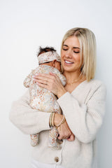 pearl zipper footies being held by karen newborn girl